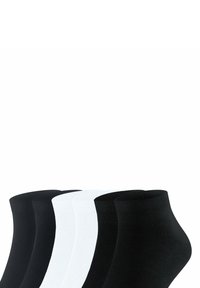 Τέσσερα ζευγάρια κάλτσες αστραγάλου σε μαύρο και άσπρο χρώμα, τοποθετημένα δίπλα δίπλα σε απλό φόντο.