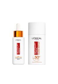 Sérum Revitalift Clinical avec un capuchon orange et pipette à côté du Fluide Anti-UV Revitalift Clinical. Les deux ont des contenants blancs avec du texte rouge.