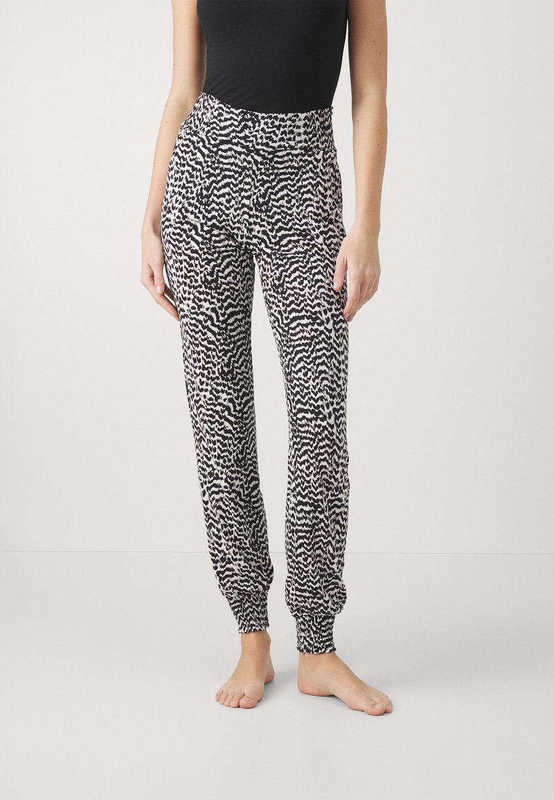 Pantalons de jogging à motifs noir et blanc avec une taille élastique et des chevilles élastiquées, fabriqués en tissu doux.