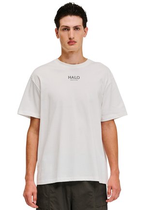 Hvid kortærmet t-shirt lavet af bomuld, med et trykt logo "HALO" på brystet. Simpelt, afslappet design med en løs pasform.