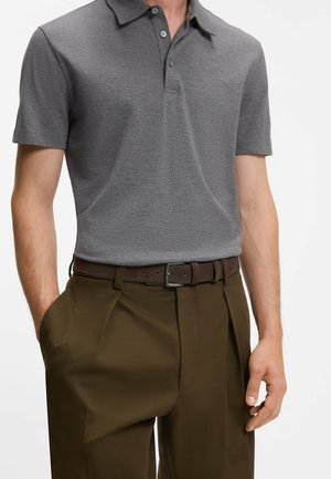 Graues Poloshirt mit Kragen, kurzen Ärmeln und drei Knöpfen. Kombiniert mit braunen Hose mit Gürtel und glatter Textur.