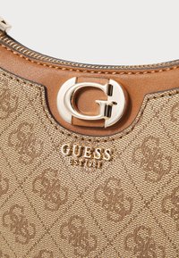 Borsa a tracolla sintetica marrone con motivo in rilievo, hardware dorato e dettaglio del logo. Chiusura superiore con cerniera e superficie texturizzata.