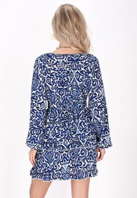 Rochie cu model albastru și alb, cu mâneci lungi, talie elastică, tiv volanat, design floral și un material moale, ușor.