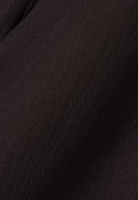 Gros plan sur un tissu brun foncé étroitement tissé avec une texture visible et un motif de tricot fin.