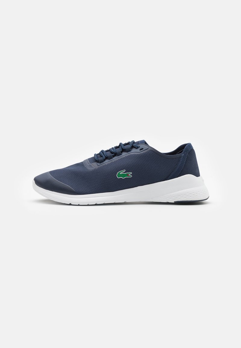 Navy sneaker with a textured mesh upper, smooth rubber accents, white sole, and tonal laces. Features a small green logo detail.