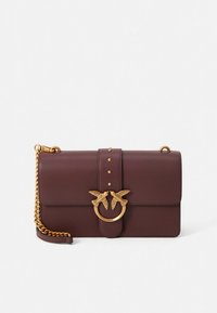 Burgundy leather handbag with a gold chain strap, featuring a decorative gold bird motif and studded accents on the front flap.