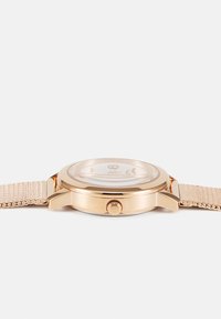 Runde roségoldene Uhr mit einem Mesh-Armband, ausgestattet mit einer glatten Lünette, klarem Glaszifferblatt und einem schlichten Ziffernblatt mit minimalen Markierungen.