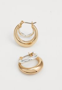 Orecchini a cerchio in oro e argento con un design a strati. Il cerchio superiore è in oro lucido e il cerchio interno è in argento lucido. Chiusura semplice a gancetto.