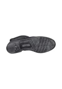Suela de bota de cuero negro con patrones texturizados, marcada con la marca "JOSEF SEIBEL." Ligero desgaste evidente en la superficie.