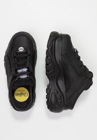 Svarta lädersneakers med snörningsdesign, vadderad krage och strukturerad gummisula. Har blå innersula och logodetalj på tungan.