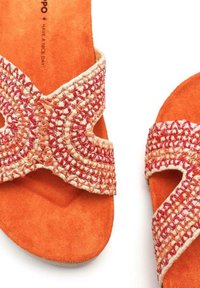 Sandali arancioni slip-on con cinturini intrecciati in rosso e crema, realizzati in morbido camoscio e con design aperto davanti.