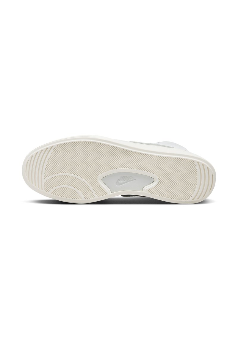 Sole di sneaker bianca con un motivo a spina di pesce, con un logo Nike visibile, materiale in gomma liscia e un design del tacco leggermente sollevato.