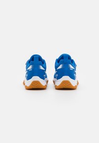 Baskets de sport bleues avec une tige en tissu texturé, des accents blancs et une semelle en caoutchouc naturel. Comprend une languette à l'arrière et un design en maille respirante.