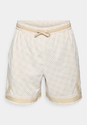Shorts beiges avec un motif perforé, taille élastique et cordon de serrage. Présente des accents beiges contrastants sur les côtés et les ourlets.