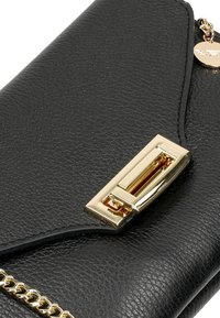 Portafoglio in pelle nera testurizzata con chiusura in metallo dorato e dettaglio a catena. Presenta un design elegante e un'apertura a pattina.