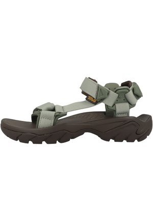 Sandale d'extérieur avec une semelle épaisse marron et des sangles réglables vert clair, dotée d'un design respirant et d'une semelle à crampons robustes pour une bonne adhérence.