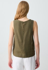 Top senza maniche in lino verde oliva con scollatura rotonda, dettaglio a trimestre sul retro e una vestibilità rilassata. Tessuto liscio, senza motivi o dettagli.