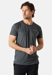 Grå idrottströja med ett strukturerat randmönster, kort ärm, rund halsringning och logotypdetalj på bröstet. Matchad med svarta shorts.