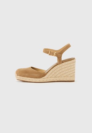 Tan suede wedge sandal with a rounded toe, ankle strap, and a textured jute-wrapped platform. Features a gold buckle accent.