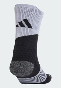 Chaussette de sport noire et grise avec une texture côtelée et un motif rayé. Comprend un talon rembourré et un logo audacieux en noir sur le côté.