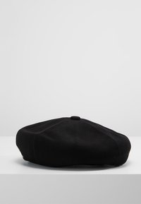 Berretto nero realizzato in morbido tessuto lavorato a maglia, con forma rotonda, bottone centrale in cima e design testurizzato.