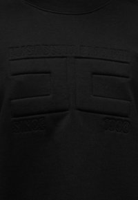 Μαύρο φούτερ με υφασμένο λογότυπο που αναγράφει «STANCE» και «1996» με ανάγλυφη κεντητική. Απλή σχεδίαση με στρογγυλή λαιμόκοψη και λείο τελείωμα.