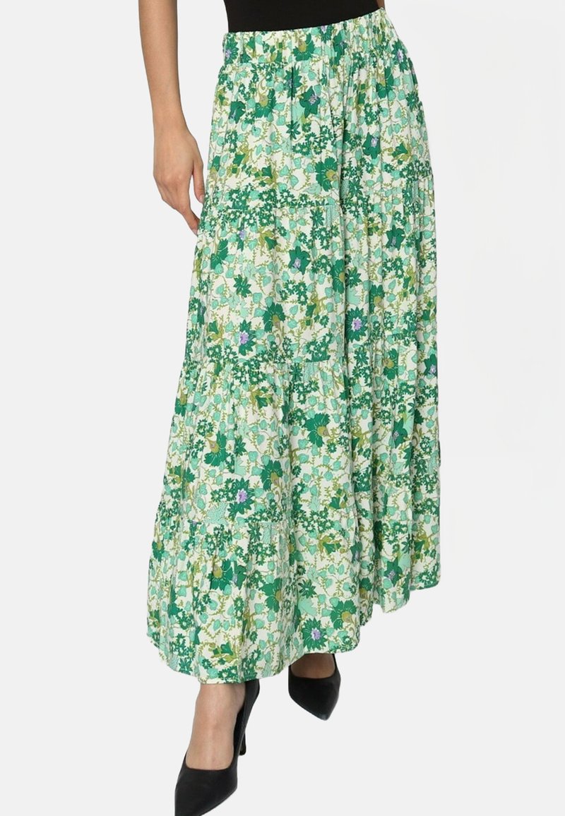 Jupe maxi florale dans des tons de vert avec un design à volants, fabriquée en tissu léger. Dispose d'une taille froncée et de motifs de diverses plantes.