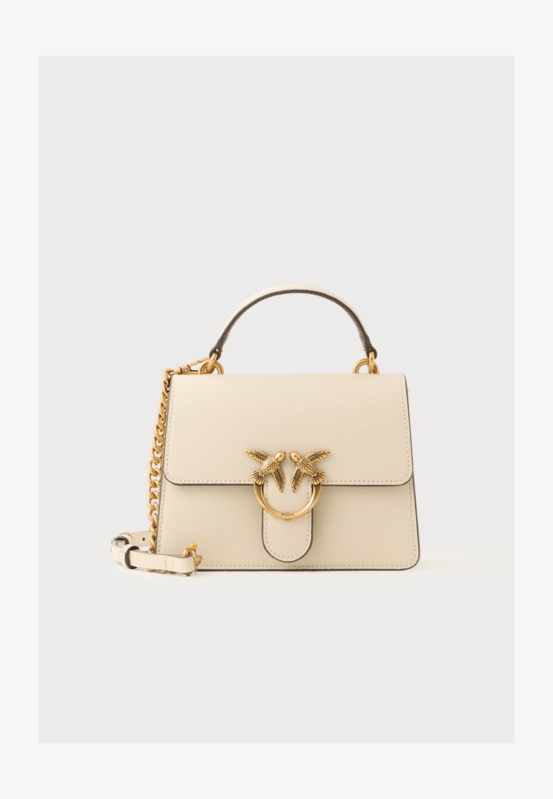 Bolsa de mão de couro creme com um design estruturado, apresentando um detalhe em forma de pássaro em tom dourado e alça de corrente. Inclui uma alça superior e fecho magnético.