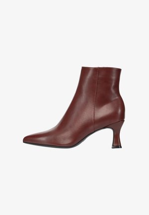 Brauner Leder-Stiefelette mit spitz zulaufender Spitze und niedrigem gebogenem Absatz, seitlich auf weißem Hintergrund dargestellt.