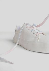 White sneaker with a smooth surface, featuring pastel pink and blue laces, rubber sole with textured grip, and reinforced heel details.
