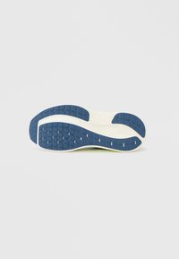 Σόλα παπουτσιού με μπλε ελαστική υφή που διαθέτει σχεδιασμένο πέλμα, λευκή μέση σόλα με λείο φινίρισμα και διακριτικό καμπυλωτό σχέδιο.