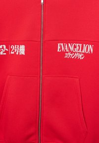 Roter Kapuzenpullover mit Reißverschluss aus weichem Stoff, mit einem vorderen Reißverschluss und zwei Taschen. Zeigt "EVANGELION" in weißem Text auf der Brust.