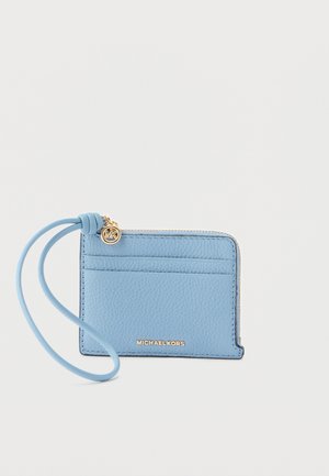 Világoskék bőrből készült kártyatartó csuklópánttal, arany cipzárral és Michael Kors arany feliratos logóval, egyszínű háttéren.