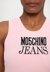 Top de alças rosa em malha com o texto "MOSCHINO JEANS" em letras pretas em negrito, com alças largas e decote redondo.