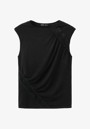 Blouse noire sans manches avec encolure bateau, ornée de détails en dentelle diagonale sur l'épaule droite supérieure et le bas du côté gauche.