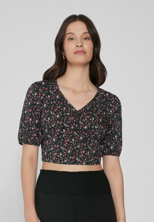 Blusa negra con estampado floral, cortada, con mangas cortas abullonadas, que presenta patrones de flores en rosa y blanco, escote en V profundo y tela texturizada.