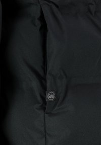 Schwarze Daunenjacke mit einem glatten, strukturierten Außenmaterial, horizontalem Steppmuster und einem kleinen Markenetikett auf der unteren linken Seite.