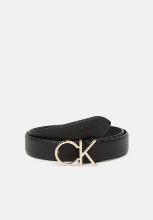 Ceinture en cuir noir texturé enroulée avec une boucle aux initiales « CK » dorées.
