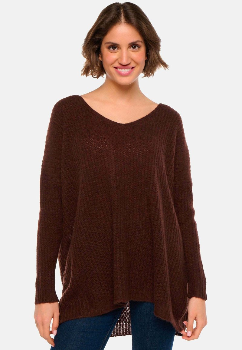 Pull en maille bordeaux avec un col en V, des manches longues, une coupe ample et une texture côtelée. Il dispose d'un ourlet asymétrique et d'un tissu doux et léger.