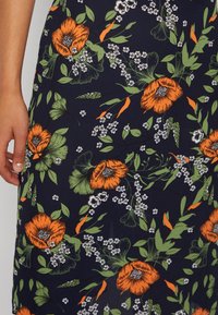 Vestido marinho com padrões florais, apresentando papoulas laranjas e flores brancas, com folhas verdes, padrões delicados e uma textura de tecido suave.