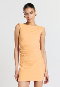 Pfirsichfarbendes, ärmelloses Kleid mit Bootsausschnitt und Rüschendetails. Figurbetonte Silhouette, gefertigt aus glattem Stoff mit leichtem Glanz.
