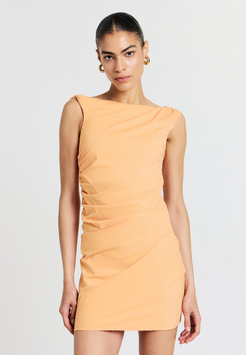 Pfirsichfarbendes, ärmelloses Kleid mit Bootsausschnitt und Rüschendetails. Figurbetonte Silhouette, gefertigt aus glattem Stoff mit leichtem Glanz.