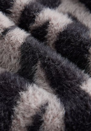 Tela peluda con un patrón de rayas en negro y beige claro, con una superficie suave y texturizada y fibras de longitudes variadas.