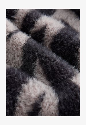 Plišani materijal s uzorkom crnih i svijetlo bež pruga, s mekom, teksturiranom površinom i vlaknima različite duljine.