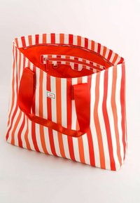 Pásková taška na rameno s červenými a bílými vertikálními pruhy, s výrazným oranžovým interiérem a pevným červeným textilním uchem. Obsahuje zipovou kapsu.