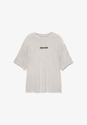 Tricou oversized gri deschis cu mâneci scurte, având inscripția "PINK FLOYD" imprimată cu text gri închis pe față. Textură de țesătură moale.