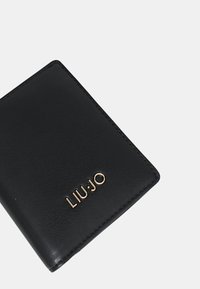 Portafoglio in pelle nera con superficie texturizzata, caratterizzato da un logo dorato in rilievo "LIU.JO" sulla parte anteriore in basso. Design rettangolare compatto.