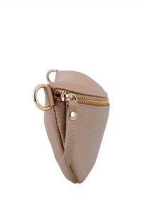 Klein beige gestructureerd leren etui met gouden ritssluiting, gouden ring en leren ritstrekker op witte achtergrond.