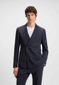Marineblauer Nadelstreifen-Doppelkinnblazer aus glattem Material. Verfügt über einen Reverskragen, zwei Vorderaschen und Knopfverzierungen.