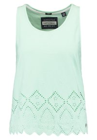 Mintgrön ärmlös topp med rund halsringning och dekorativ spetsdetalj vid fållen som har urklippta mönster och vågiga kanter.